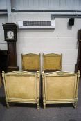 A pair of Regency style cream and green painted single beds,