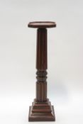 A William IV mahogany torchere with later top, gadrooned and carved column on a stepped base,