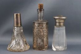 Three silver mounted clear glass scent bottles,comprising a tapering example,