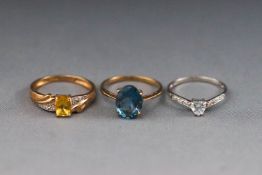 A selection of three dress rings consisting of a yellow heliodor and diamond,