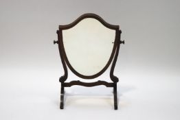 An Edwardian mahogany shield shape swing frame mirror