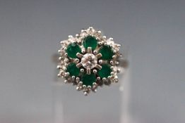 An 18ct white gold diamond and emerald cluster ring, 1ct diamonds, 8 g,