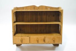 A Victorian pine wall hanging shelf unit with three drawers below three shelves,