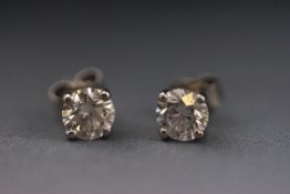 A modern white metal pair of single stone earrings each set with round brilliant cut diamond