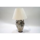 A decorative terracotta two handled jar, converted to a table lamp with shade,