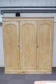 A pine triple wardrobe with four drawers and a box storage,