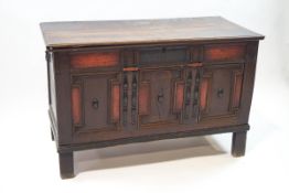 A 17th century oak coffer, the panelled front with half pillar and geometric moulding,