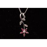 A white metal flower pendant set with pink tourmaline and diamonds.