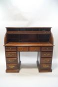 A mid-20th century oak roll top pedestal desk with ten drawers,