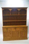 A 20th century pine dresser, the two shelf rack over three drawers and cupboards,