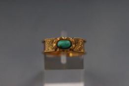 An 18ct and turquoise band ring with scroll engraved shoulders. Stamped 18c. Size P leading edge. 3.