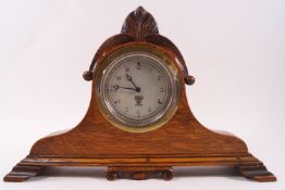 A Smiths car clock set into a carved oak surround,