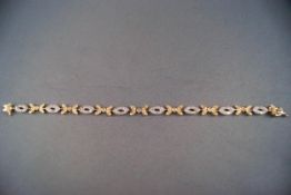 A 14ct white and yellow gold diamond floral tennis style bracelet, 1.75ct diamonds, 9.