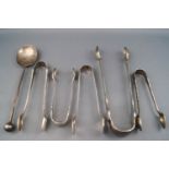 Five silver sugar tongs, George III and later, together with a silver spoon with ball finial,