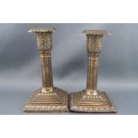 A pair of silver short square cluster-column candlesticks with stepped square bases and nozzels,