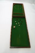 An Edwardian mahogany bar billiards with two cues and nine balls,
