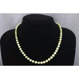 An early 20th century jade bead necklace, the beads graduated approx. 6.5mm - 4.