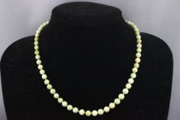 An early 20th century jade bead necklace, the beads graduated approx. 6.5mm - 4.