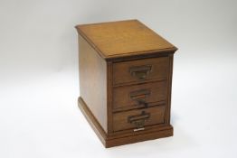 An oak Shannon three drawer filing cabinet, label to interior,