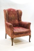 A wing back armchair on front mahogany cabriole legs
