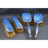 A silver and blue enamel four piece dressing table set comprising of a pair of hair brushes and a
