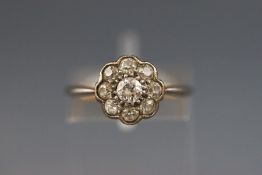 A yellow and white metal diamond cluster ring set with nine old brilliant cut diamonds.