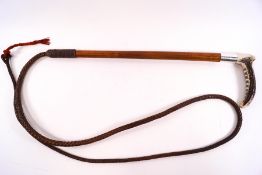 An early 20th century Huntsman's carriage whip with plaited leather thong and silver collar,