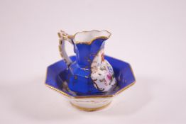 A Coalport porcelain miniature jug and basin, painted with flower sprigs on royal blue ground,