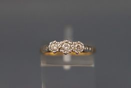 A yellow and white metal three stone diamond ring. Stamped 18ct & Plat. Size: N 2.
