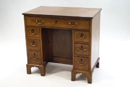 A George III mahogany desk with original swan drop brass handles, ebony escutcheons,