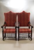 A pair of Victorian oak throne chairs, heavily carved scroll arms on turned and block supports,