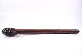 An African hardwood ceremonial club, the end carved as a grimacing man,