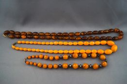A collection of three strung bakelite beaded necklaces to include one brown,