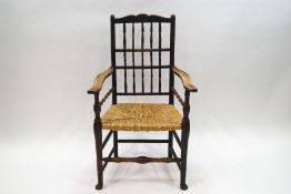 A 19th century Norfolk elm spindle back chair with rush seat