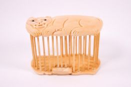An early 20th century Japanese ivory cricket cage, the top carved as a big cat,