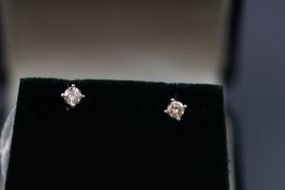 A modern white metal pair of single stone diamond stud earrings. Estimated 0.28ct total.