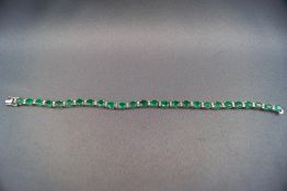 An 18ct white gold emerald and diamond bracelet. Emeralds 9.93ct and diamonds 0.63ct.