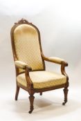 A Victorian mahogany show frame armchair with carved foliate crest, scroll arms and carved supports,