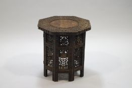 An Indian octagonal hardwood table, the top with central brass plant inlay,