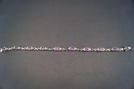 A silver purple cubic zirconia cluster bracelet. Stamped 925. 16.