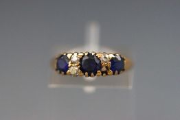 A yellow metal half hoop ring set with synthetic sapphire and diamond (One diamond missing).