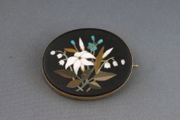 A Victorian gold and pietra dura oval brooch depicting a flower spray with forget me nots and