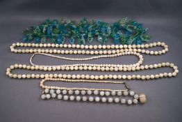 A green and blue glass bead necklace, four mother of pearl necklaces and white beaded necklace.