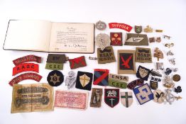 A quantity of WWII military cap badges, including cloth examples,