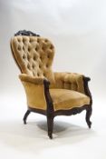 An Edwardian rosewood button back armchair, carved foliate scroll crest rail,