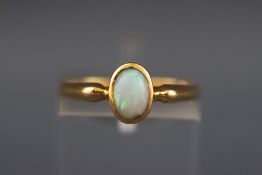 A yellow metal single stone cabochon opal ring. Hallmarked 18ct gold, Birmingham, 1971 Size; M 1.