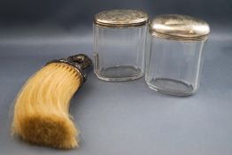 A silver mounted wig brush, with embossed loop handle,