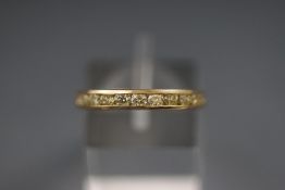 A yellow metal channel set half hoop ring. Stated weight of 0.76 carats. Hallmarked 9ct, Sheffield.