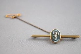 A yellow metal bar brooch with central carved cameo.