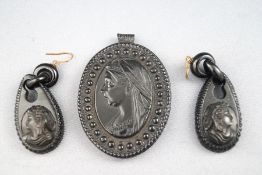 A Whitby pendant and a pair of matching earrings of religious design. 27.